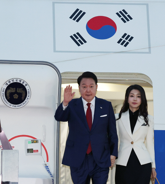 인도네시아 아세안(ASEAN)·인도 주요 20개국(G20) 정상회의 일정을 마친 윤석열 대통령과 부인 김건희 여사가 11일 오전 성남 서울공항을 통해 귀국, 전용기인 공군 1호기에서 내리며 영접객들에게 손을 들어 인사하고 있다. 연합뉴스